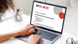 Close up girl in front of computer and screen shows IELTS information