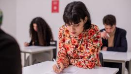 Lady in floral red taking test at centre with a pen